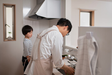 Obraz premium 子供に料理の仕方を教えるお父さん