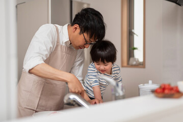 Obraz premium 子供に料理の仕方を教えるお父さん