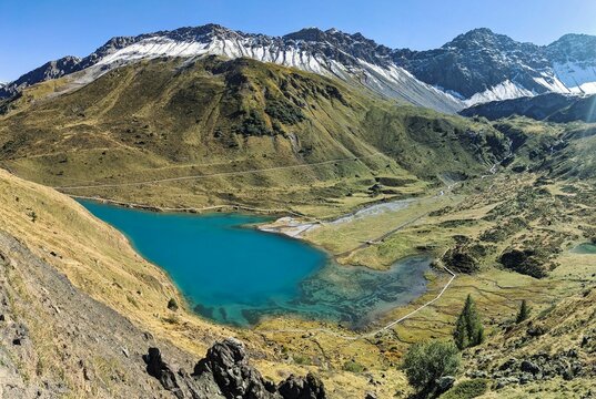 Schwellisee above Arosa. Wonderful autumn panorama in Graubunden. Beautiful mountain lake in the valley between the high mountains. High quality photo