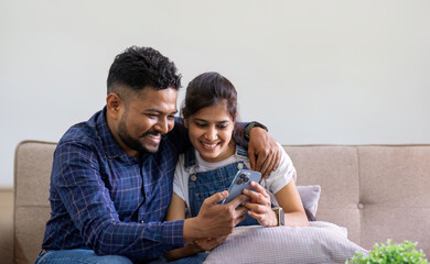 The triumph of a young Indian couple happily celebrates reading unexpected good news on their...