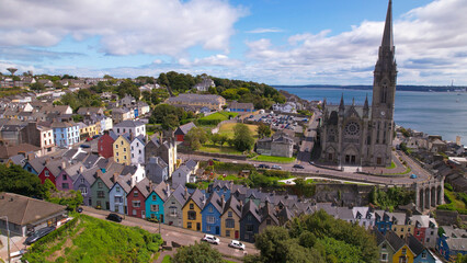 Aerial view of St. Coleman’s Cathedral and the Deck of Cards, a gravity-defying row of candy-colored houses stacked on a vertiginous hill, in Cobh, Ireland.