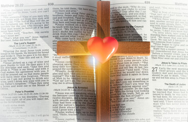 wooden cross heart on the background of the bible