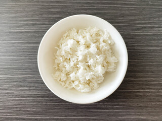 Thai jasmine rice in white bowl on wood