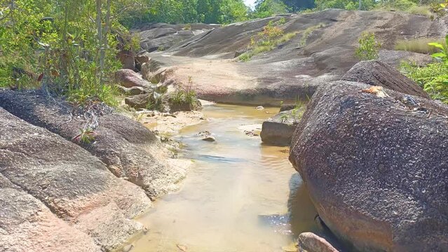 A Stream Of Fresh Water Flows Between The Rocks. Small River Flows Between Boulders In A Mountain Forest. Daya Baru Indonesia