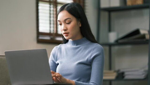 Asian charming person sit hold netbook browsing have good mood working home indoors.