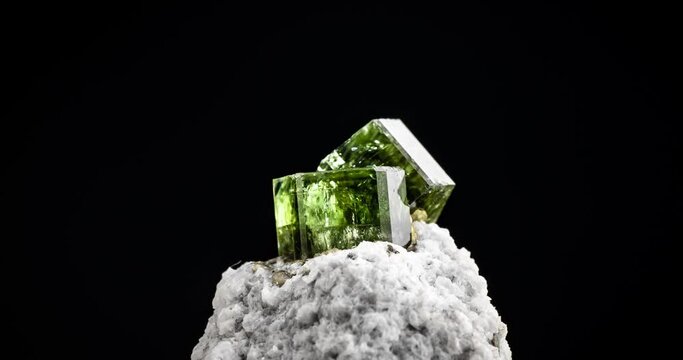 green Fluorapatite on matrix 360&deg; loop rotating on black background. macro detail close-up rough raw unpolished semi-precious gemstone.