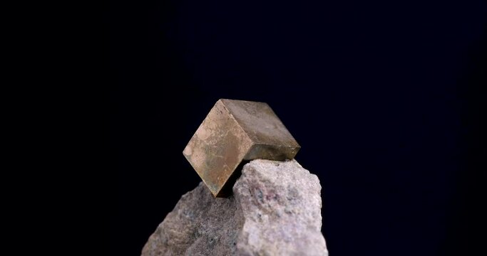 pyrite cube on matrix 360&deg; loop rotating on black background. macro detail close-up rough raw unpolished semi-precious gemstone.