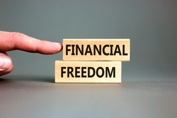 Financial freedom symbol. Concept words Financial freedom on beautiful wooden blocks. Beautiful grey table grey background. Businessman hand. Business financial freedom concept. Copy space.