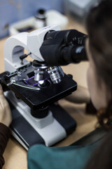 Scientist looking through microscope in laboratory