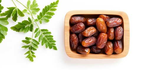 Fototapeta premium Pattern of dates with leaves in a wooden bowl isolated on a white background with copyspace for text