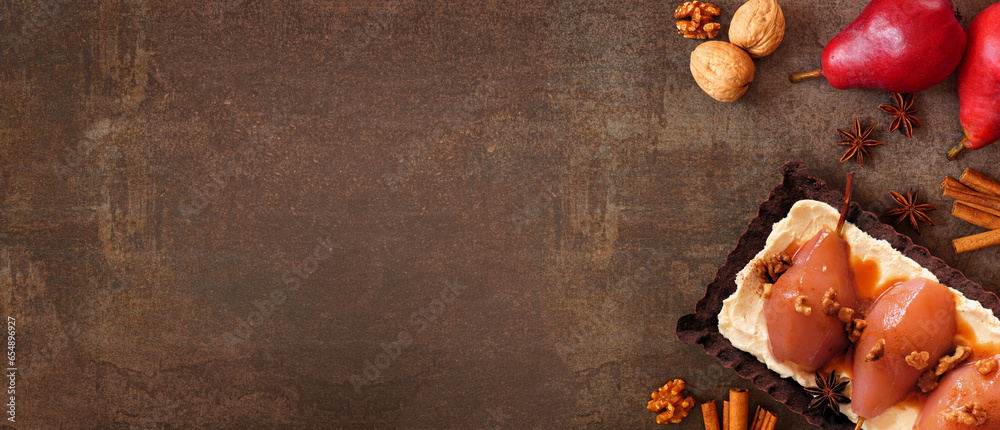 Poster Spice poached pear tart. Above view side border table scene over a dark stone banner background. Copy space.