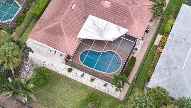 Above drone photo of screened in pool and lanai in florida houses 