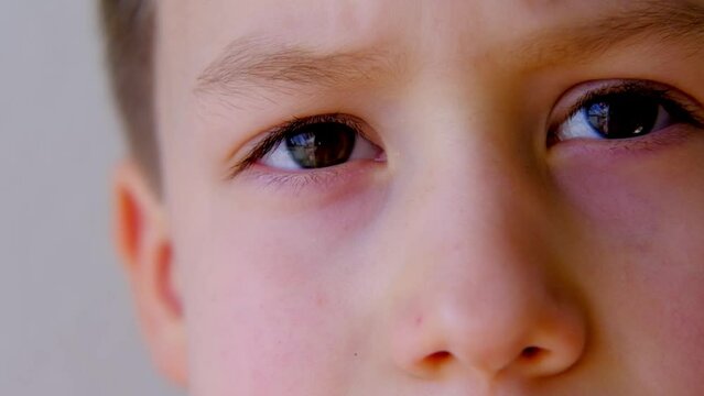 close-up of part of the child's face, boy 8-10 years old Asian-European appearance, human eye looking seriously at the camera, the concept of surveillance, peeping, tracking