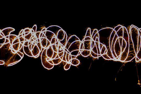 Long exposure, light painting photography. 3d rendering. Bright glow lights shape at motion on isolated with black background. Abstract neon wallpaper. Fireworks in the night.