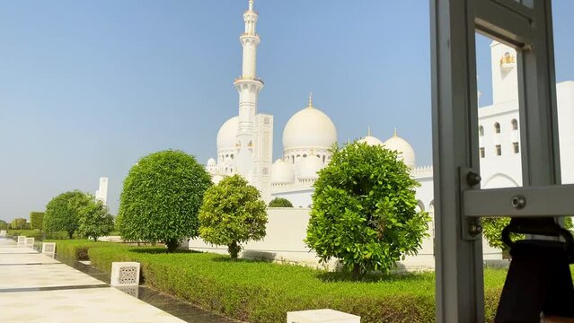 Abu dhabi, UAE - 3rd october, 2022: passengers point of view transfer service around Sheikh Zayed Grand Mosque pillars and Abu Dhabi exterior details