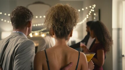 Couple announcing engagement to friends at drinks party who congratulate them - shot in slow motion