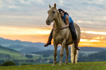Horse and equestrian team: A young woman and her palomino caballo deporte espanol horse during...