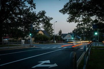 Blurred Motion of Fast Car in City Traffic with Illuminated Light Trails. Blur of illuminated tail lights on a fast city highway.  City Street at Dusk with Car Light Trails and Reflections