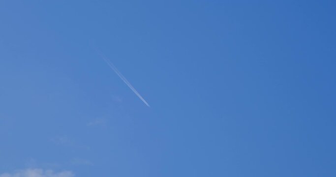 Airplane flying on deep blue sky with chemical direction trails