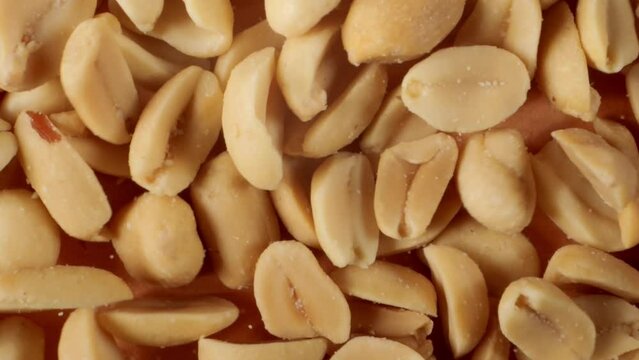 Salted roasted peanuts. Peanuts seeds close-up. Salty snack. Salted peanuts snack food.