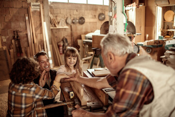 Young future carpenters learning the ways of their elders in a wood shop