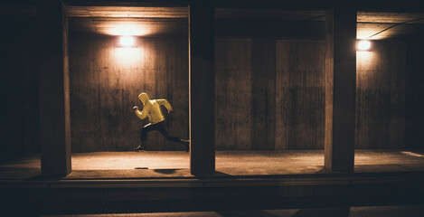 Young man sprinting under a bridge in the city