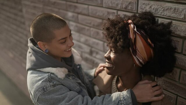 Young interracial lesbian couple sharing a moment while waking in the city