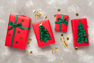 Creative handmade christmas gift boxes with decor on concrete background, top view