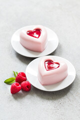 Italian dessert. Raspberry cream Panna Cotta in the shape of a heart with raspberry sauce in the...