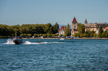 Obraz premium Motorboat with people wakeboarding. Lake Geneva and Castle of Ouchy. Ouchy, Lausanne, Switzerland.