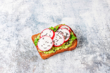 Avocado toasts with cherry tomatoes and raddish slices,sesame seeds.