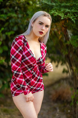 Fototapeta premium Stunning blonde beauty modeling outdoors in red flannel pajamas