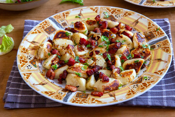 A traditional Polish cuisine dish: potato dumplings with bacon and onion