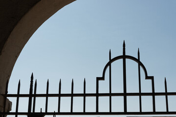 gate iron work and rounded architectural feature on a blue sky
