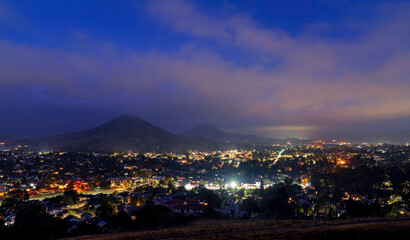 hazy morning with city lights, mountain, sky