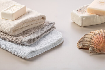 Fototapeta na wymiar Bathroom accessories. Stack of towels, soap and shell on the dressing table