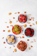Superfood, raw healthy vegetarian snack, Medjool dates covered by chocolate, and various energy balls with nuts.