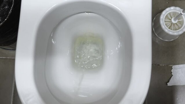 View from above. A man pees down the toilet.