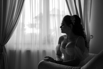 a bride sitting in the window light. Black and white