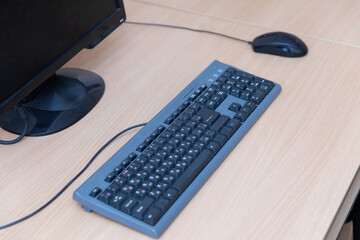 The keyboard and mouse manipulator are black on the table near the monitor.