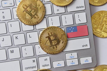 national flag of Samoa on the keyboard with bitcoin coins on a grey background.