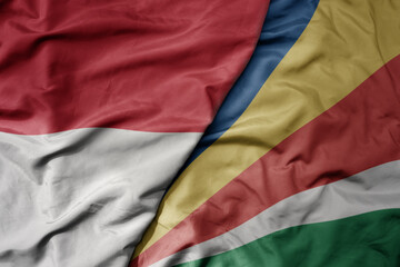 big waving realistic national colorful flag of indonesia and national flag of seychelles .