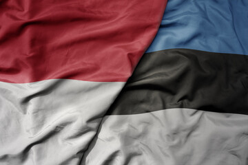 big waving realistic national colorful flag of indonesia and national flag of estonia .