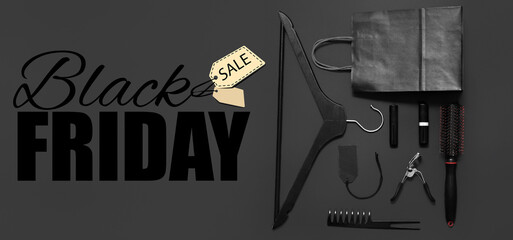 Shopping bag with clothes hanger and accessories on dark background. Black Friday sale