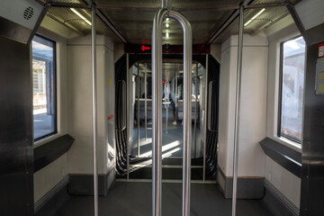 Interior del vagón del metro, donde los pasajeros ocupan los asientos dispuestos a lo largo del...