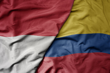 big waving realistic national colorful flag of indonesia and national flag of colombia .