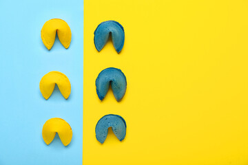 Composition with blue and yellow fortune cookies on color background