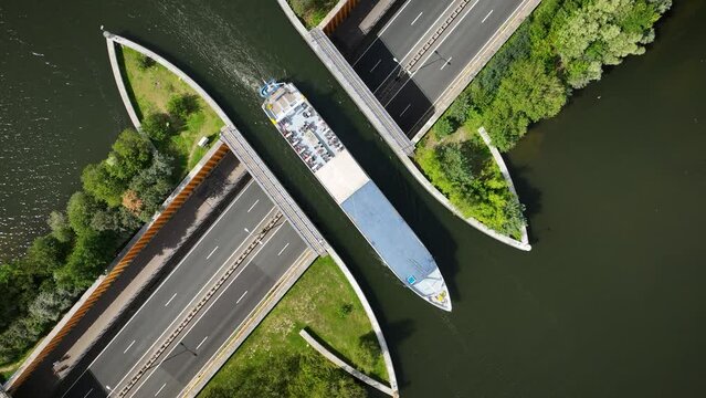 Aerial footage of a tourist ferry passing the aqueduct Veluwemeer above the highway. View of water bridge Aquaduct Veluwemeer allowing vehicular and waterborne traffic to pass over or under one anothe