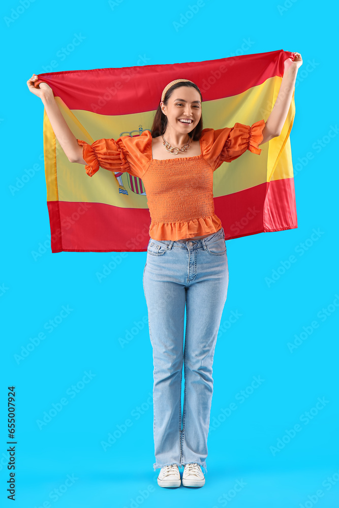 Poster Pretty young woman with flag of Spain on light blue background