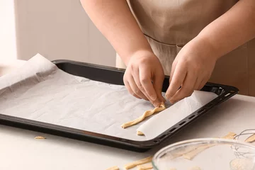 Gordijnen Woman placing Italian Grissini into baking tray at white table in kitchen © Pixel-Shot